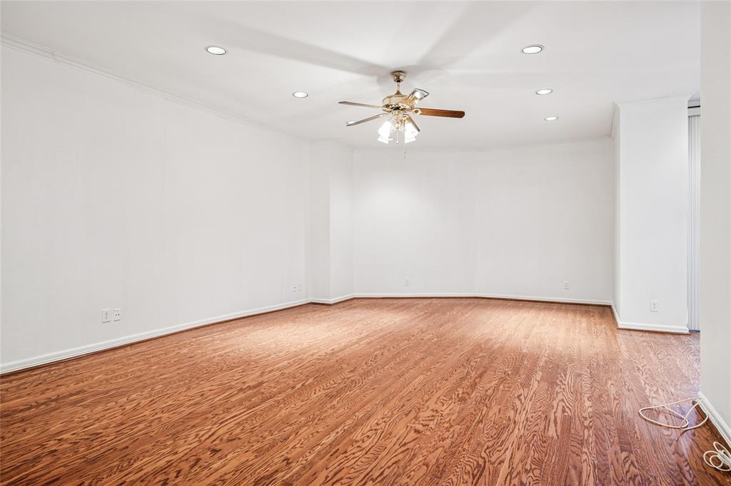 5200 Keller Springs Road, Unit 110 Dallas, TX 75248 - Photo 6 of 28 an empty room with wooden floor and fan