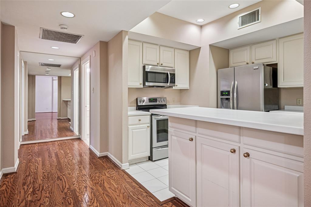 5200 Keller Springs Road, Unit 110 Dallas, TX 75248 - Photo 10 of 28 a kitchen with stainless steel appliances granite countertop a refrigerator and a stove top oven
