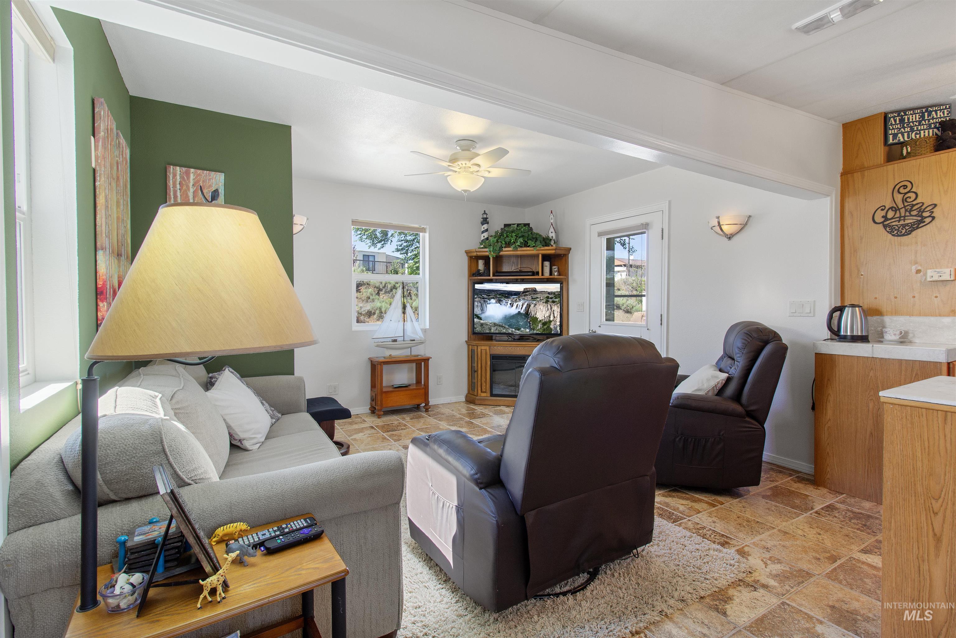106 West Magic Road Shoshone, ID 83352 - Photo 10 of 45 Living space featuring neutral wall paint, a green accent wall, and tiled flooring