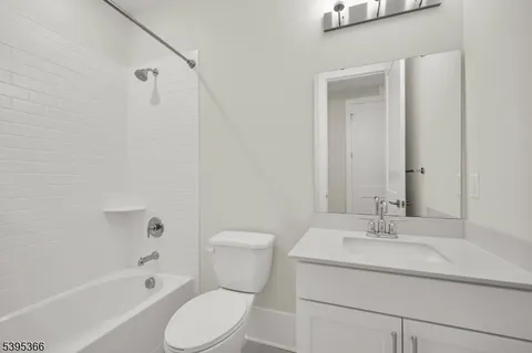 a bathroom with a sink toilet vanity and shower