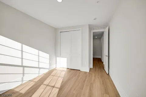 a view of a room with wooden floor and a window