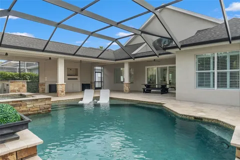 a kitchen with stainless steel appliances granite countertop a kitchen island a stove a refrigerator a sink a dining table and chairs with wooden floor