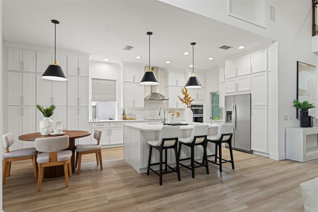 11627 Renaissance View Court Tampa, FL 33626 - Photo 6 of 62 a kitchen with stainless steel appliances granite countertop a table chairs stove and wooden floor