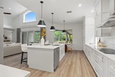 a kitchen with kitchen island granite countertop a sink a counter top space stainless steel appliances and cabinets