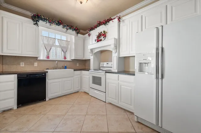 a kitchen with white cabinets and white appliances