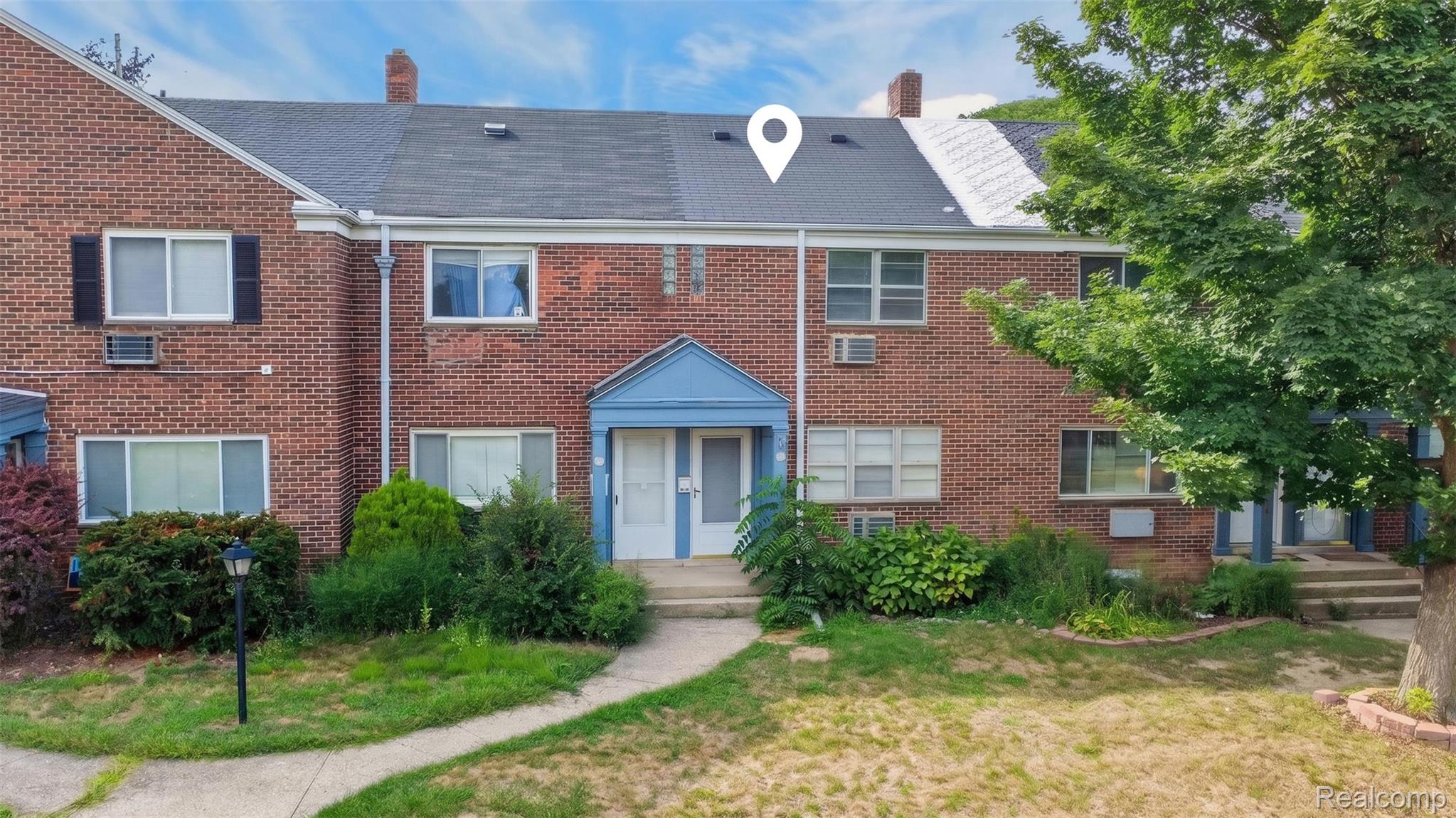 Brick exterior with dark shingle roofing