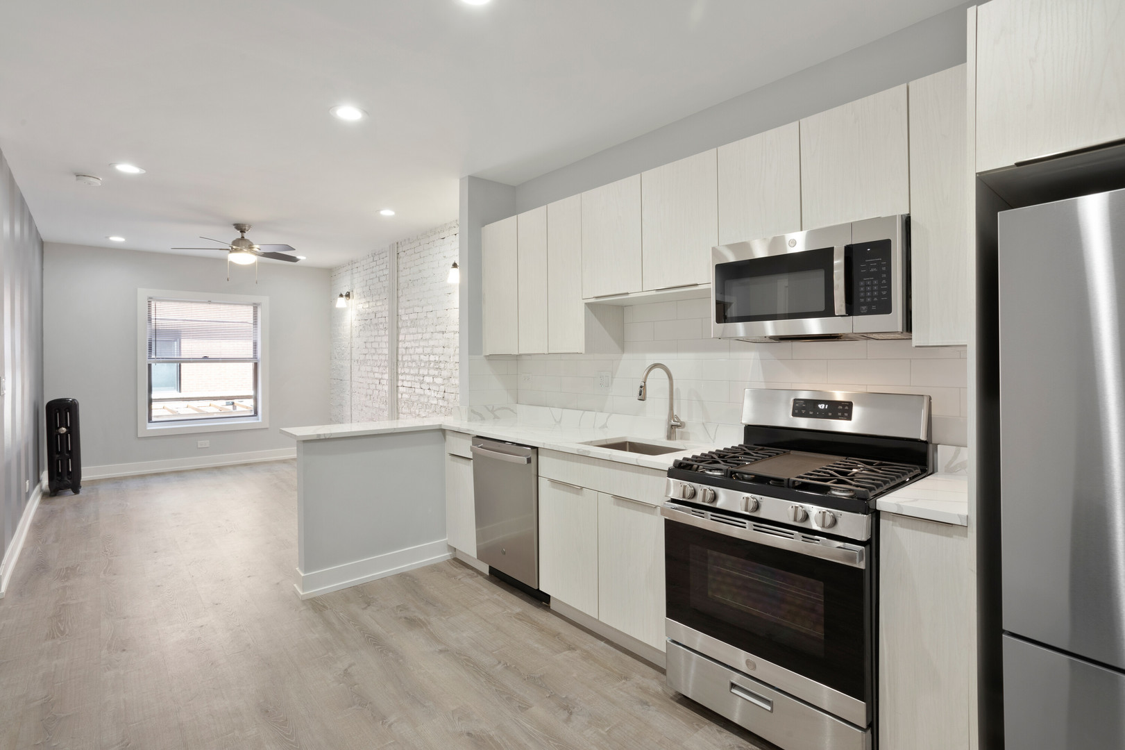 1706 West Juneway Terrace, Unit 1H Chicago, IL 60626 - Photo 2 of 17 a kitchen with stainless steel appliances a stove microwave and sink