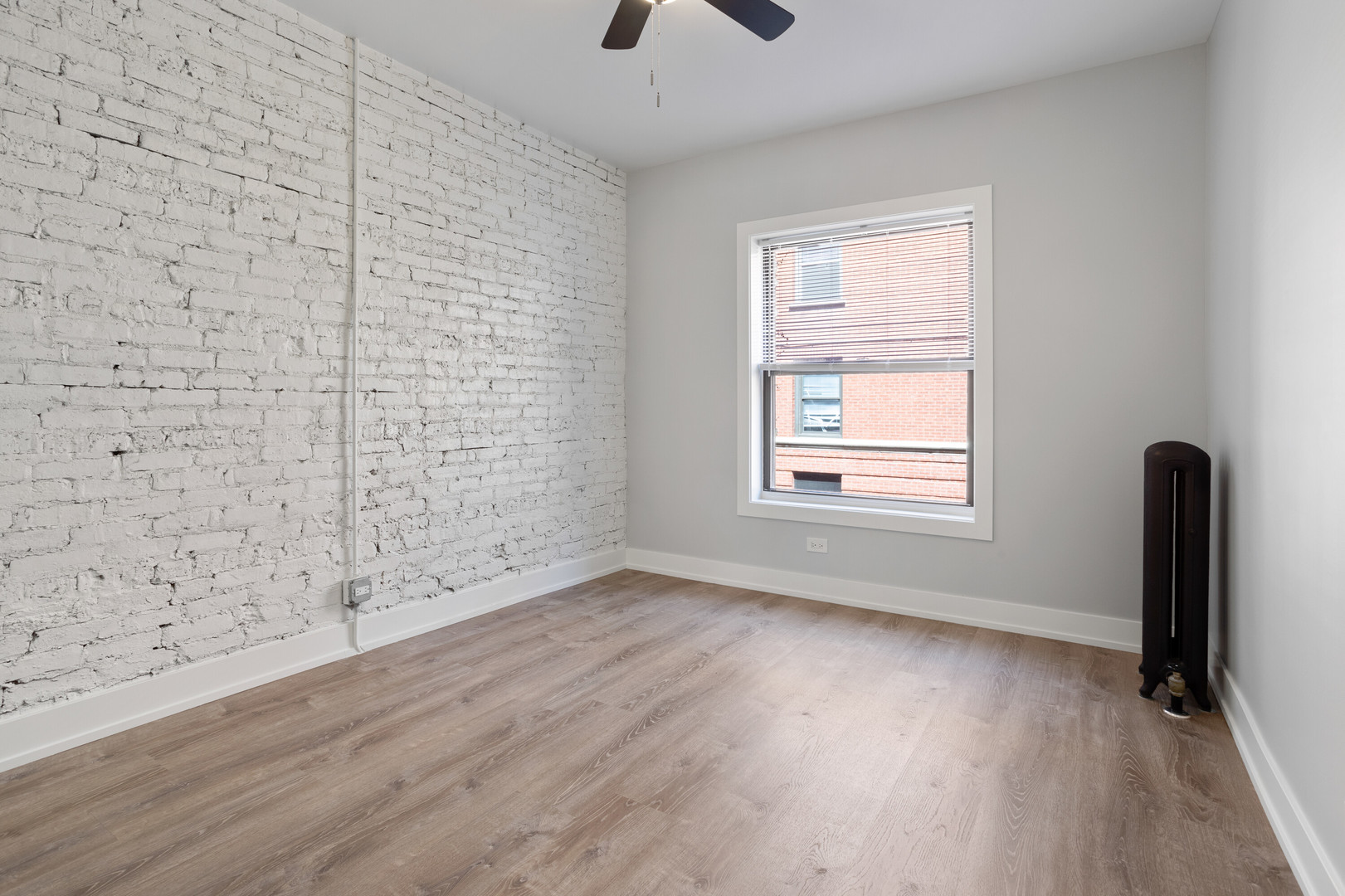 1706 West Juneway Terrace, Unit 1H Chicago, IL 60626 - Photo 7 of 17 a view of an empty room with wooden floor and a window