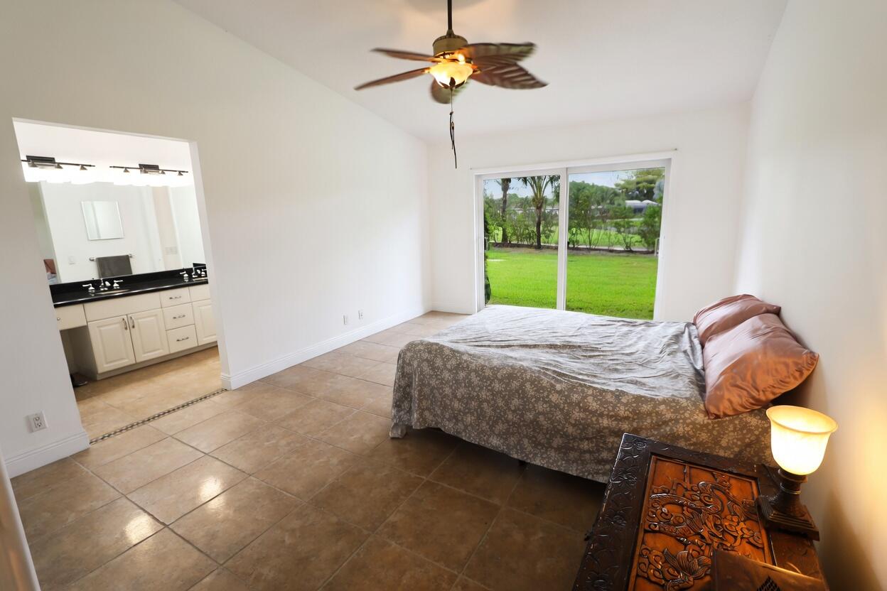 5667 North Cameo Drive Boca Raton, FL 33433 - Photo 11 of 20 a bedroom with a bed and a chandelier
