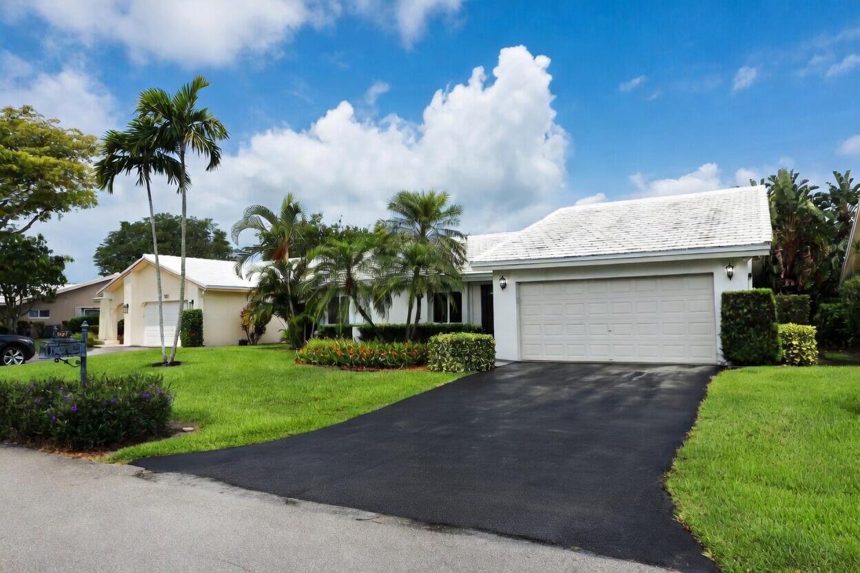 5667 North Cameo Drive Boca Raton, FL 33433 - Photo 2 of 20 a front view of a house with a garden and a yard