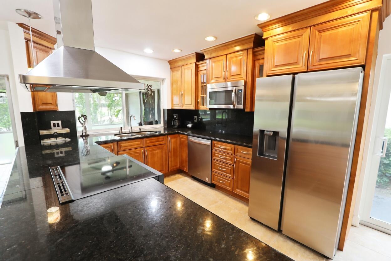 5667 North Cameo Drive Boca Raton, FL 33433 - Photo 4 of 20 a kitchen with stainless steel appliances granite countertop a refrigerator a stove and a sink with granite countertops
