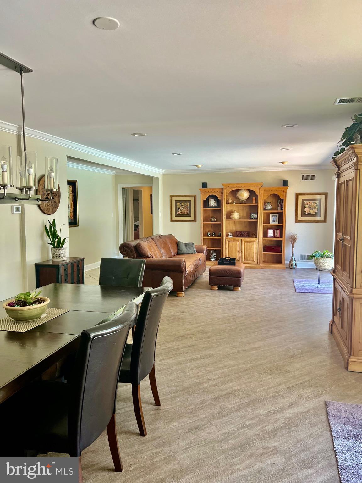 1542 Crowell Road Vienna, VA 22182 - Photo 29 of 55 a living room with furniture a chandelier and a wooden floor