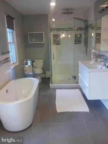 a bathroom with a tub a toilet and a sink