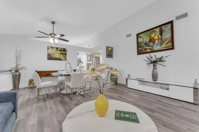 a living room with furniture a chandelier and a flat screen tv