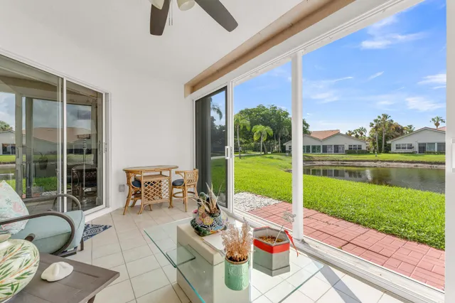 a view of a patio with couches chairs and a floor to ceiling window