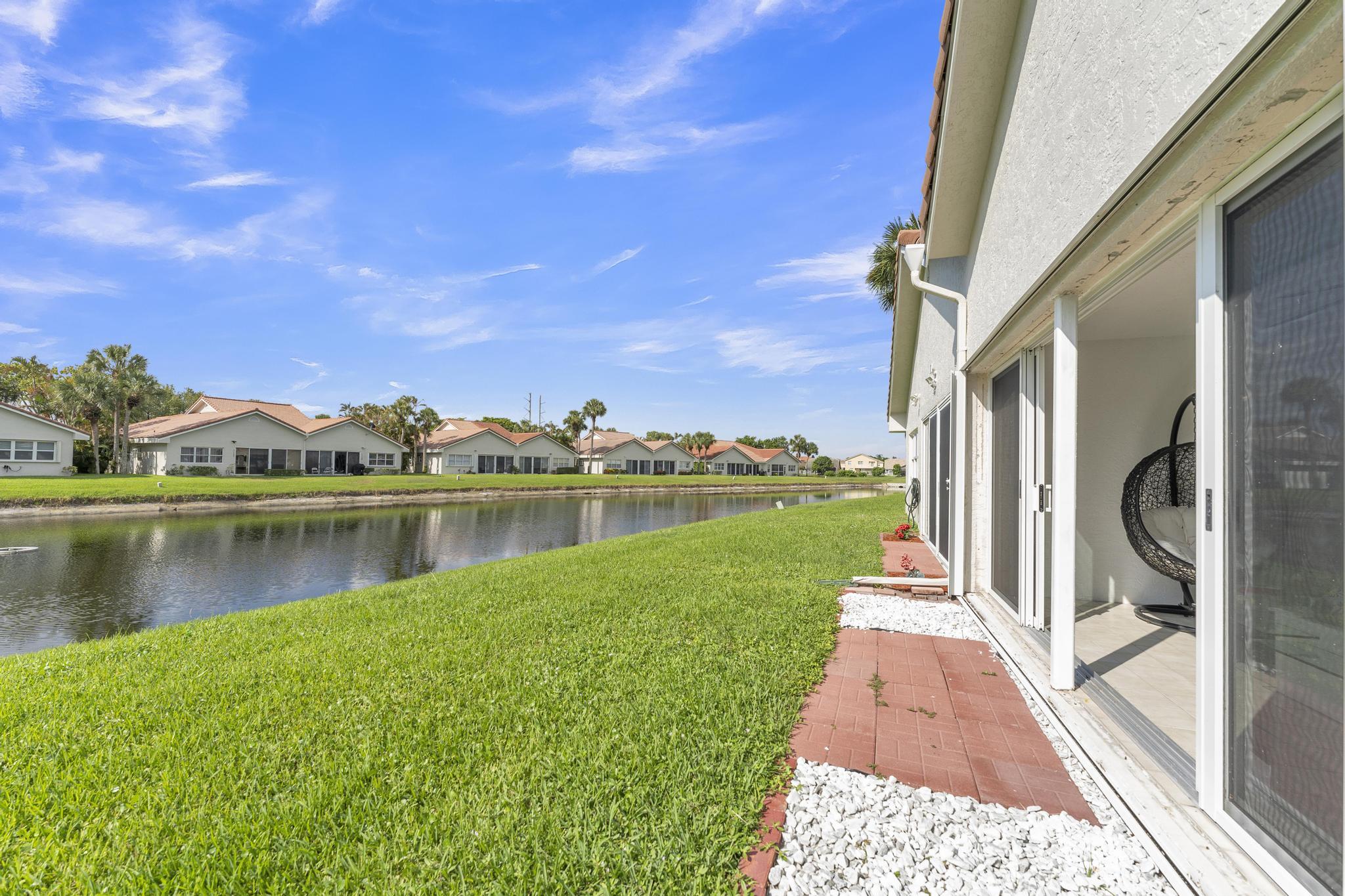 11120 Sangria Court Boca Raton, FL 33498 - Photo 31 of 34 a view of a lake with a yard