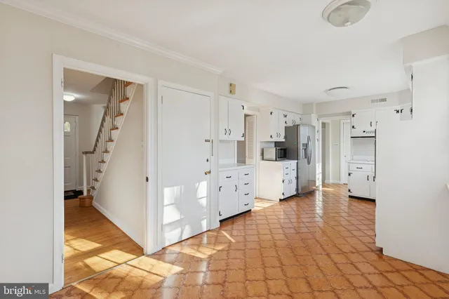 a large white kitchen with a sink and refrigerator
