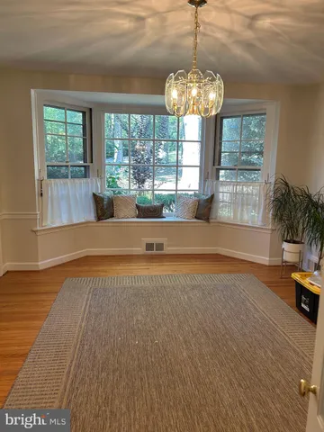 a spacious bedroom with a large bed and a chandelier