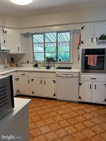 a kitchen with stainless steel appliances a stove a sink and a microwave