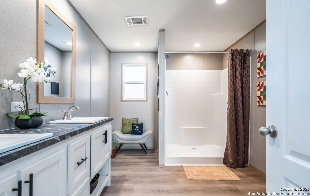 4124 Wegner Road New Braunfels, TX 78132 - Photo 10 of 12 a bathroom with a granite countertop sink a toilet and shower