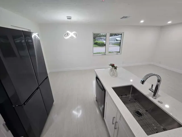 a kitchen with a sink a refrigerator and cabinets
