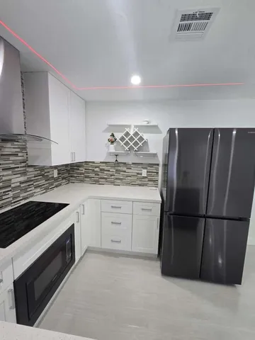 a kitchen with a refrigerator stove and cabinets