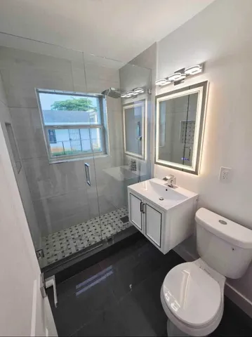 a bathroom with a sink a toilet and shower
