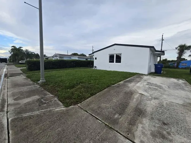 a view of a house with backyard and trees
