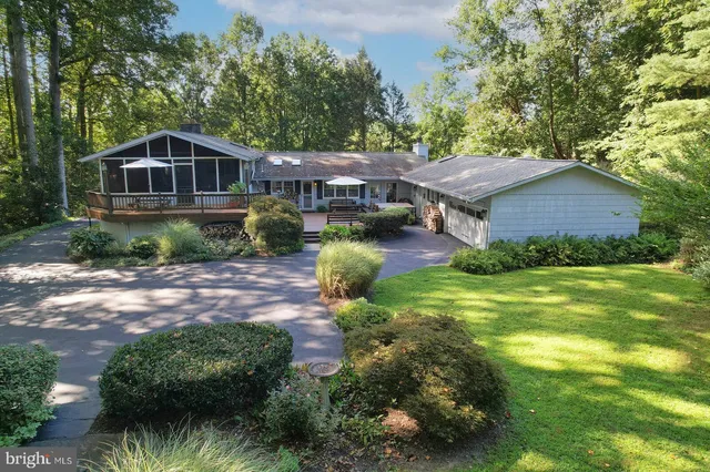 a aerial view of a house next to a big yard and large trees