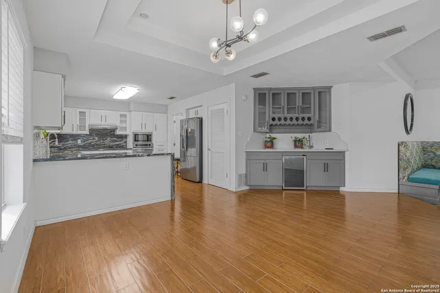 a kitchen with stainless steel appliances granite countertop a stove a sink and white cabinets