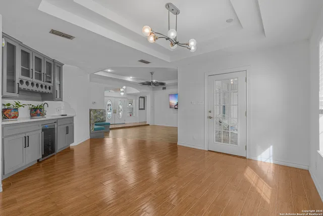 a kitchen with stainless steel appliances granite countertop a refrigerator a stove a sink dishwasher and white cabinets with wooden floor