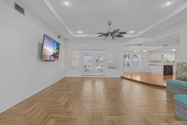 a view of an empty room with window and wooden floor