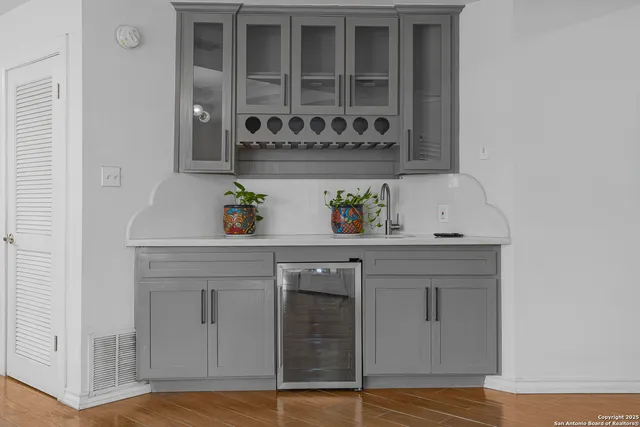 a view of kitchen with stainless steel appliances granite countertop a refrigerator a stove top oven a sink dishwasher and white cabinets with wooden floor