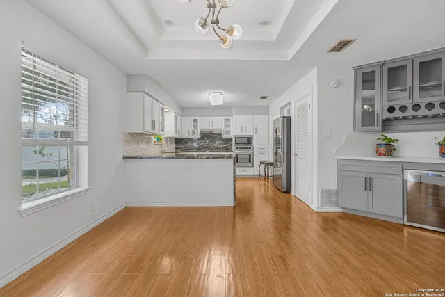 a view of a kitchen with a sink dishwasher stove and kitchen view with wooden floor
