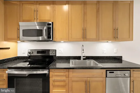 a kitchen with granite countertop a stove and a microwave