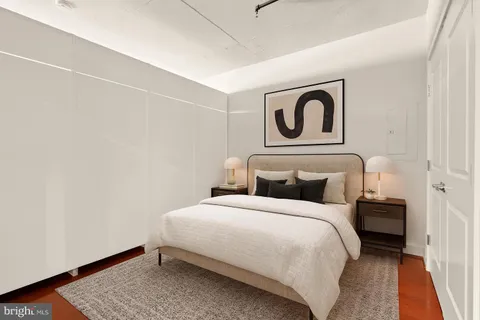 a bedroom with a bed and painting on the wall