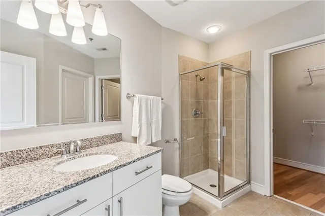 a bathroom with a granite countertop sink toilet and shower