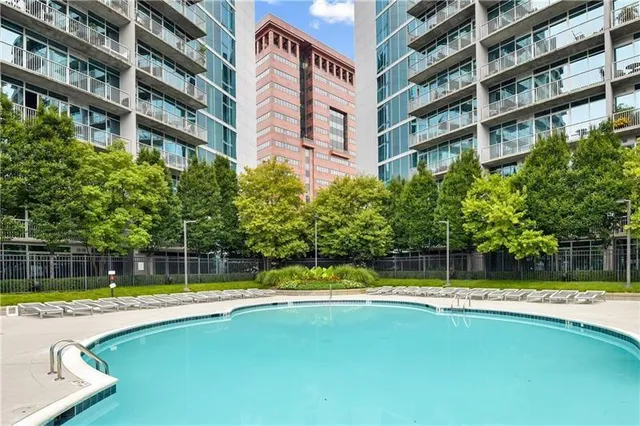 a view of building with a large pool and a large tree in front of it