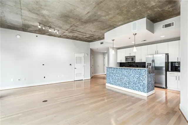 a view of kitchen with stainless steel appliances kitchen island microwave and cabinets