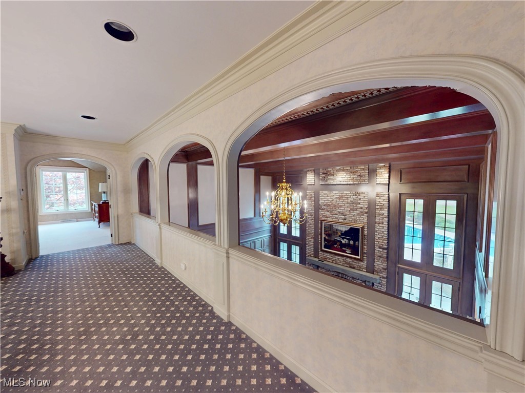 9870 Hobart Road Willoughby, OH 44094 - Photo 26 of 50 Hallway with carpet flooring, arched walkways, and a chandelier