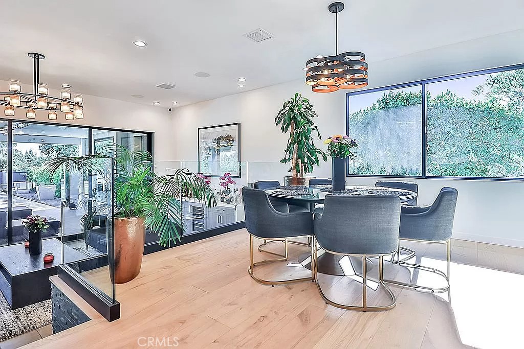 19532 Bermuda Street Porter Ranch, CA 91326 - Photo 11 of 74 a dining room with furniture a chandelier and wooden floor