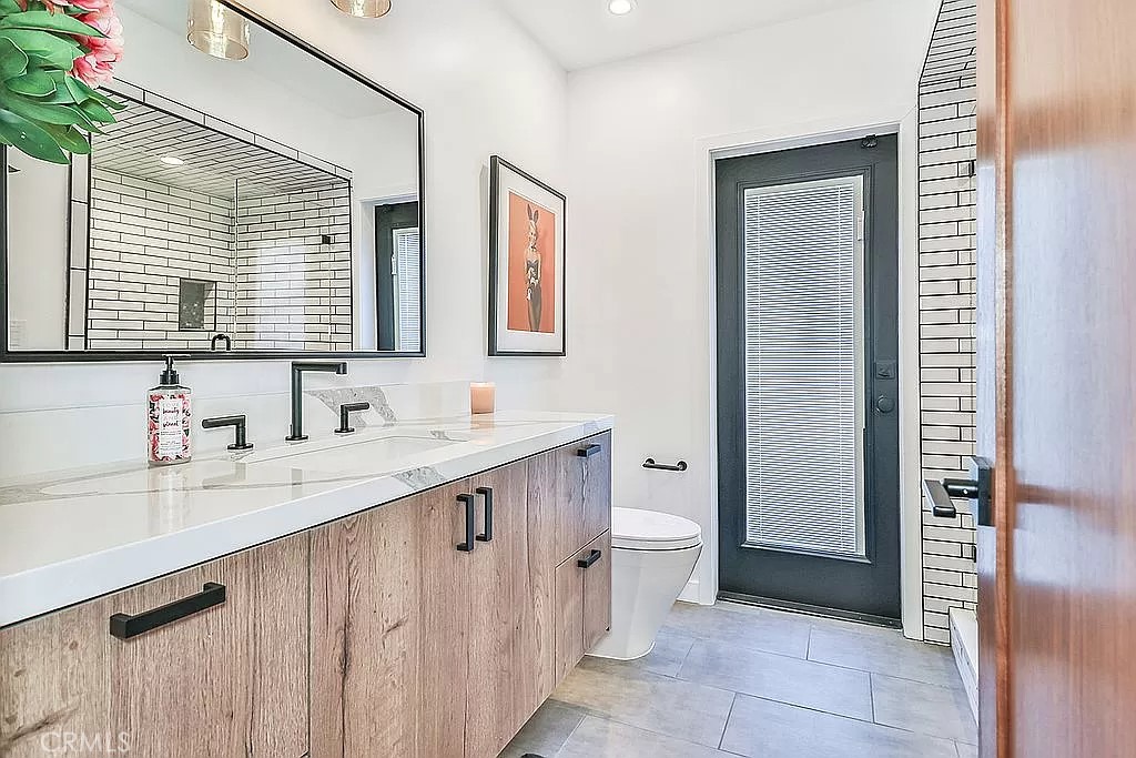 19532 Bermuda Street Porter Ranch, CA 91326 - Photo 51 of 74 a bathroom with a sink a toilet and a large mirror