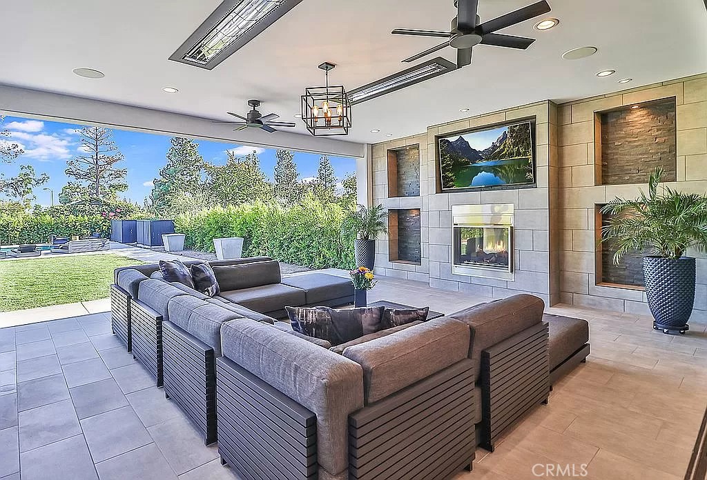 19532 Bermuda Street Porter Ranch, CA 91326 - Photo 56 of 74 a living room with furniture potted plant floor to ceiling window and a flat screen tv