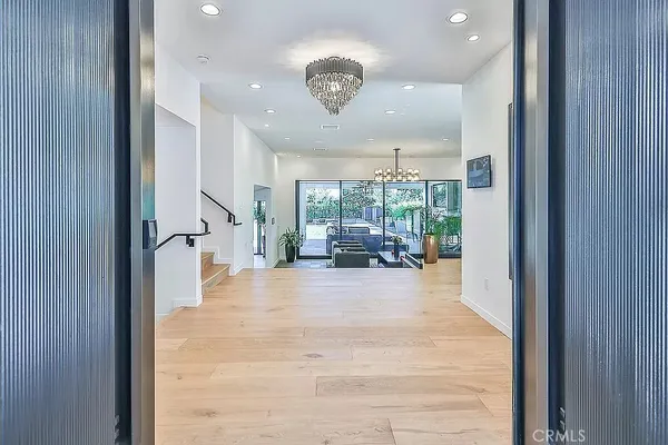 a dining room with furniture a chandelier and wooden floor