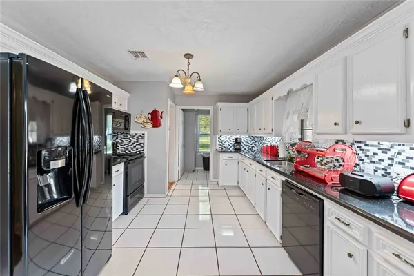 a kitchen that has a lot of cabinets and wooden floor