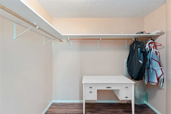 a view of walk in closet with clothes and shoes