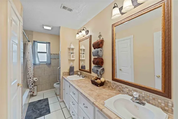a bathroom with a granite countertop sink mirror and shower