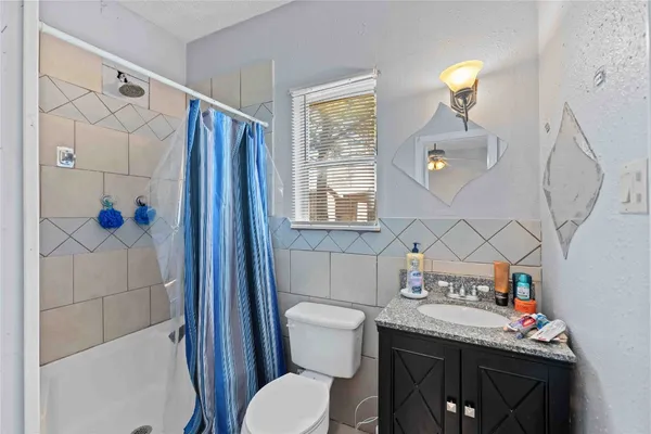 a bathroom with a granite countertop toilet sink and shower