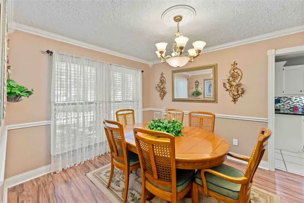 a view of a dining room with furniture a chandelier and wooden floor
