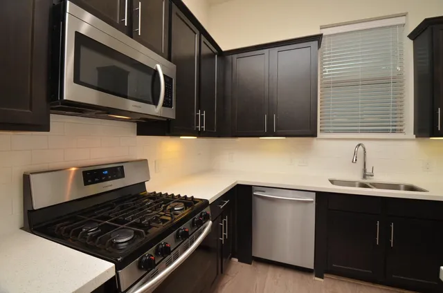 a kitchen with stainless steel appliances a sink stove and microwave